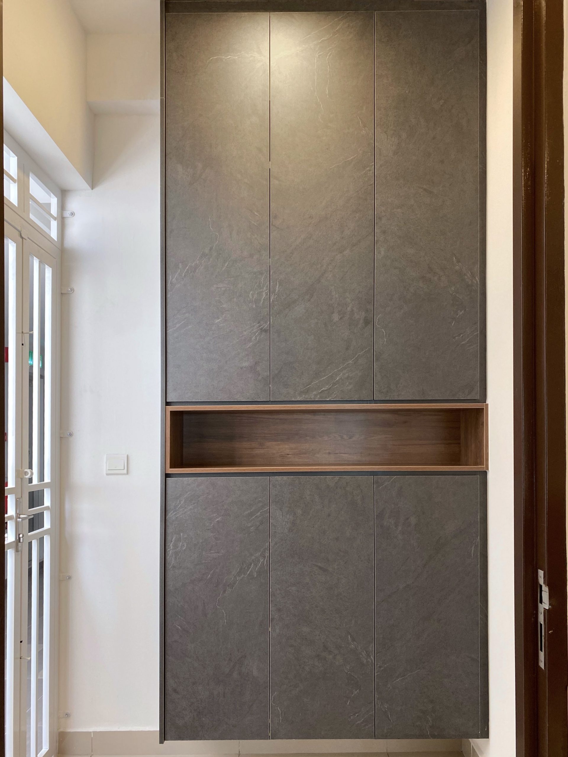 Built-in wooden shoe cabinet placed at the foyer.